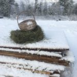 basket and hay on plywood stack in maine winter snow white pine